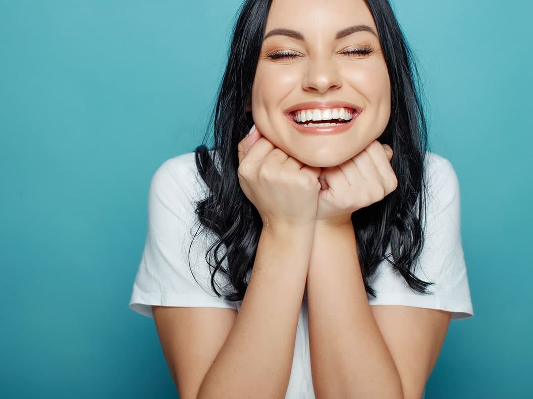 young woman with a cute smile shows off her teeth